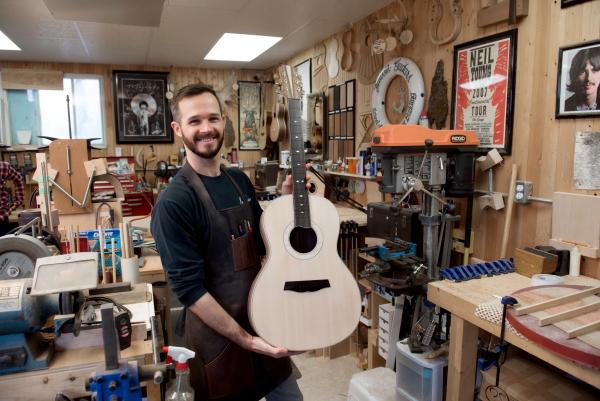 man holding hand made guitar